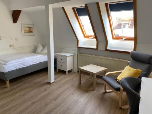 a small room with a bed and a chair at Norddeutscher Hof in Stralsund