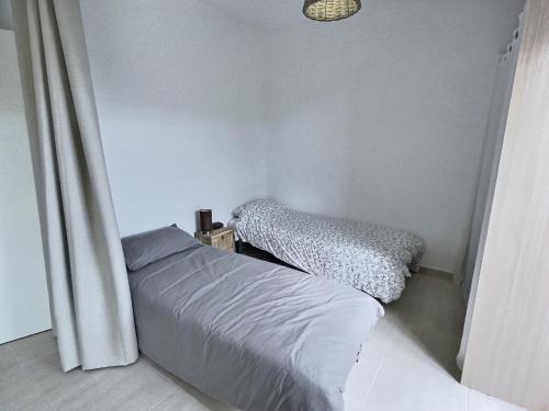 Habitación pequeña con cama y ventana en Studio à 600m de la mer dans une résidence récente, en Sérignan