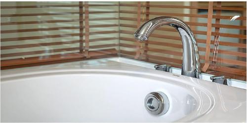 a white sink with a faucet in a bathroom at Gemini Saigon LUXURY in Ho Chi Minh City