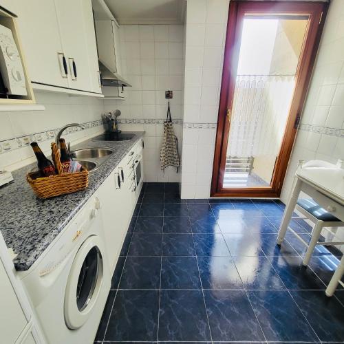 a kitchen with a sink and a washing machine at Chiqui Home in Salamanca