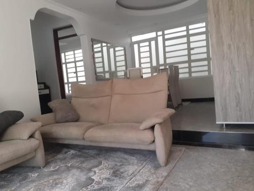 a living room with a couch and some windows at Lux suites Utawala Family House in Nairobi