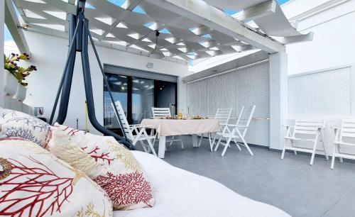 a living room with a table and white chairs at Leuca lungomare by LoveSud in Leuca