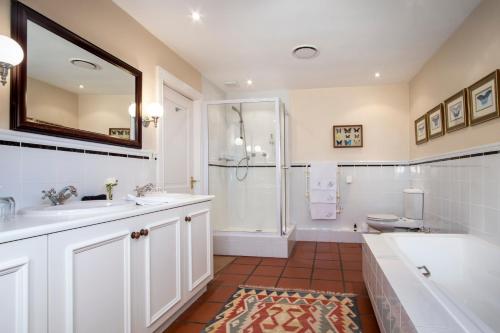 a bathroom with a sink and a shower and a toilet at La Fontaine Guest House Hermanus in Hermanus