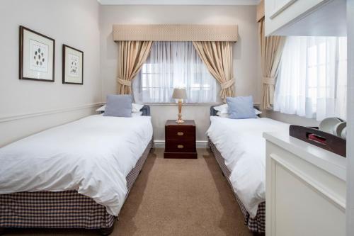 a bedroom with two beds and a window at La Fontaine Guest House Hermanus in Hermanus