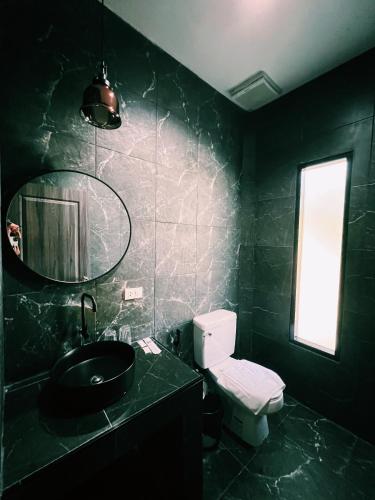 a black bathroom with a toilet and a sink at ViVi Hotel Resort in Phuket