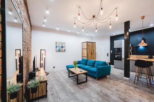 Una sala de estar con un sofá azul y una mesa. en Modern Apartments Toruń 2 Stare Miasto-Centrum, en Toruń