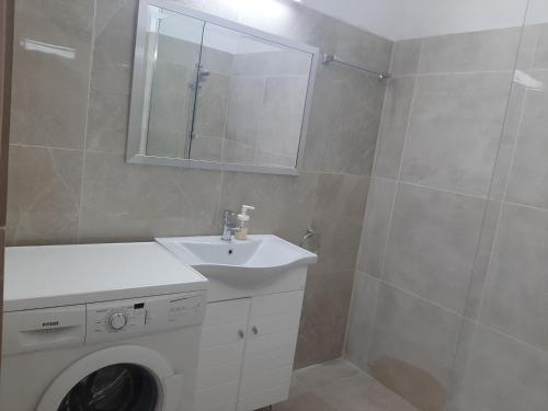 Un baño con lavadora y lavabo. en Blue Cottage, en Apsiou