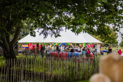 a crowd of people standing under a white tent at B&B Ter Gracht in Wevelgem