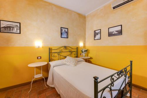 a bedroom with a bed and a table and yellow walls at La Vecchia Stazione Ravenna in Ravenna