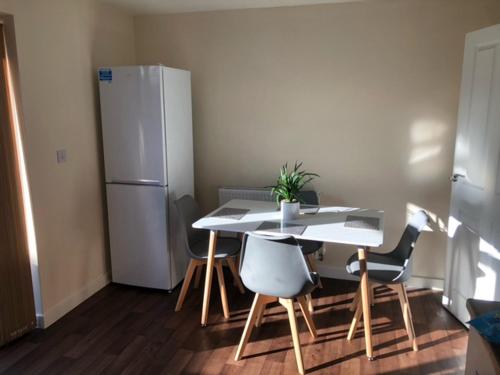 a kitchen with a table and a white refrigerator at Bray House - Perfect for Large Groups in Wolverhampton