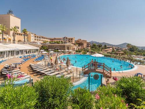 a large swimming pool with chaise lounges and a resort at Superbe studio 4/5 pers dans résidence cap esterel in Agay - Saint Raphael