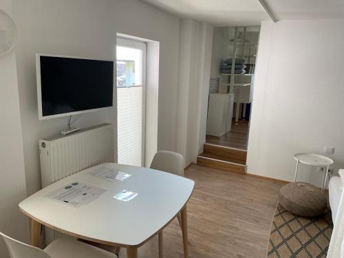 a living room with a white table and a television at MIA Lifestyle Appartements in Innsbruck