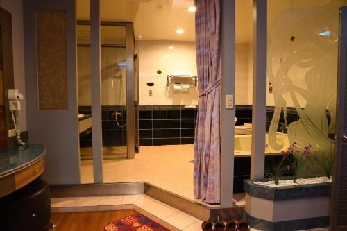 Habitación con baño con ducha y aseo. en Love Boat Motel, en Chaozhou