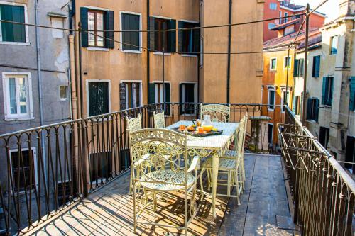 einen Tisch und Stühle auf dem Balkon eines Gebäudes in der Unterkunft La Terrazza di San Marco - Luxury Apartment in Venedig