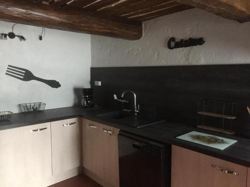 une cuisine avec un évier et un plan de travail noir dans l'établissement Gites de Fontroussière, à Flayosc