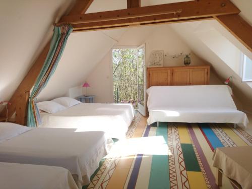a attic bedroom with two beds and a window at La Tonnelle de Vouvray in Vouvray