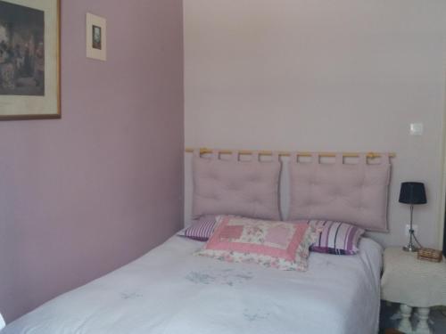 1 dormitorio con cama blanca y cabecero rosa en Cozy Apartment Near Historic Centre en Corfú