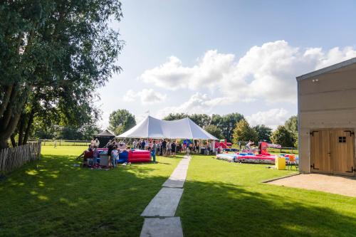 a group of people sitting under a tent in a park at B&B Ter Gracht in Wevelgem