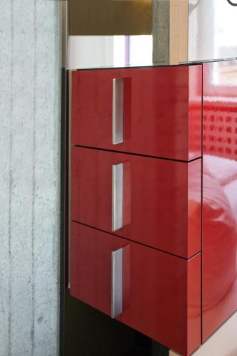 a red chest of drawers in a bedroom at Hotel Cristall - Frankfurt City in Frankfurt/Main