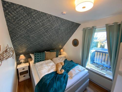 a bedroom with a bed with a teddy bear on it at Villa Gudrun, luxury Beach House in Zingst