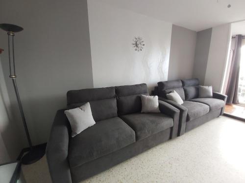 a gray couch in a living room with a lamp at Studio Cap d'Agde le Môle in Cap d'Agde