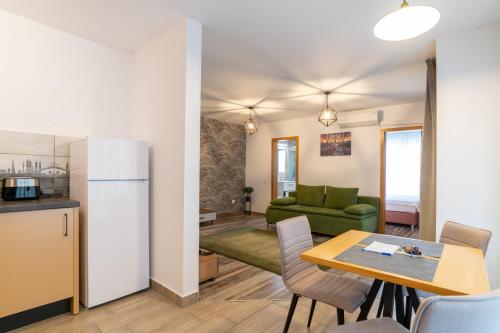 a kitchen and living room with a table and a refrigerator at TCI Apartments in Cluj-Napoca