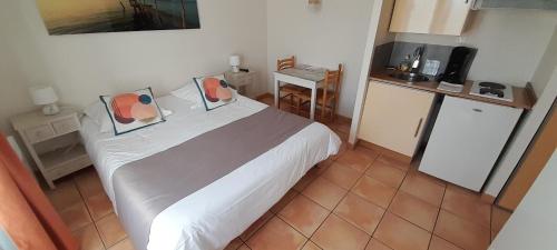 1 Schlafzimmer mit einem großen Bett und einer Küche in der Unterkunft Hôtel des Vignes in Juliénas