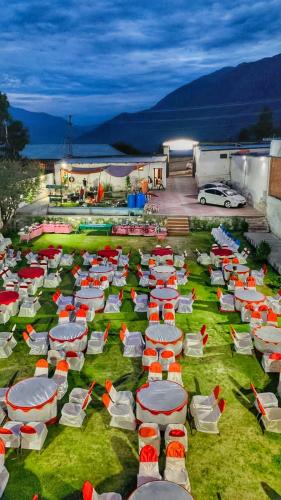 a group of lawn chairs and umbrellas on the grass at Duroyo hotel in Gilgit