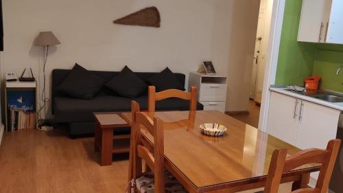 uma sala de estar com uma mesa e um sofá em Apartamento a 5 min de la playa y el centro em Almeria