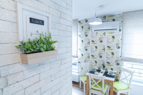 a dining room with a white brick wall at TCI Apartments in Cluj-Napoca