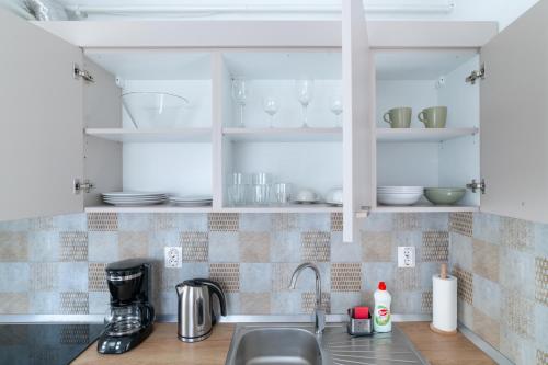 a kitchen counter with a sink and white cabinets at TCI Apartments in Cluj-Napoca