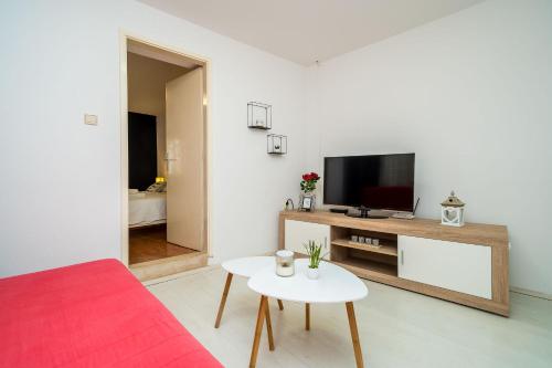 a living room with a couch and a tv and a table at Apartment Laura - Lapad in Dubrovnik