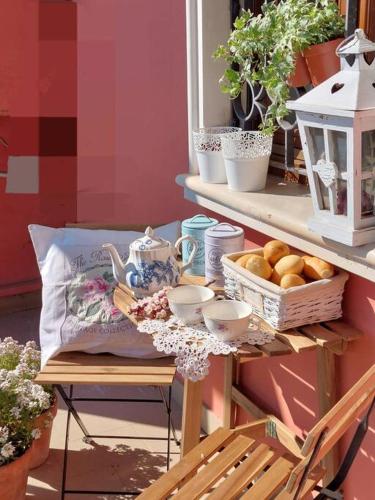a table with a tea set and a basket of food at Appartamento - Lì de Là tra i fiori in Villafranca di Verona