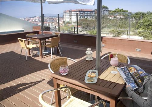 a table and chairs on a balcony with a view of a city at Santana Hotel & SPA in Vila do Conde