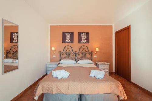 a bedroom with a large bed with two pillows at Taormina Garden Hotel in Taormina