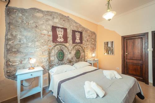 a bedroom with a bed and a stone wall at Taormina Garden Hotel in Taormina