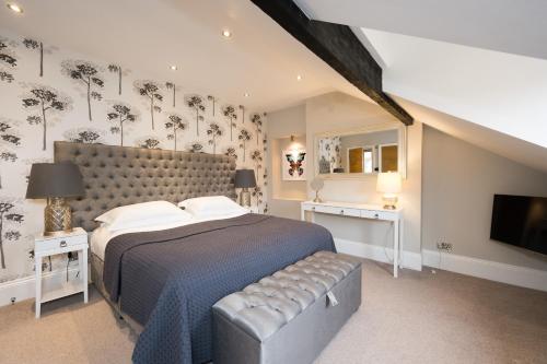 a bedroom with a large bed and a television at Harrogate Serviced Apartments - St George's Five in Harrogate