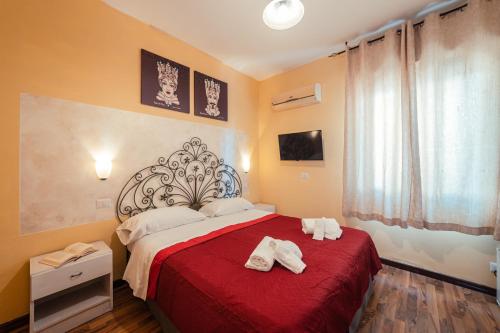 a bedroom with a red bed with towels on it at Taormina Garden Hotel in Taormina