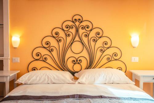 a bed with a white bedspread next to a lamp at Taormina Garden Hotel in Taormina