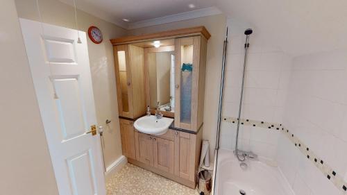 a bathroom with a sink and a toilet and a shower at The Retreat in Sidmouth
