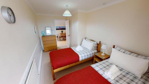 um pequeno quarto com uma cama e uma cadeira em The Retreat em Sidmouth