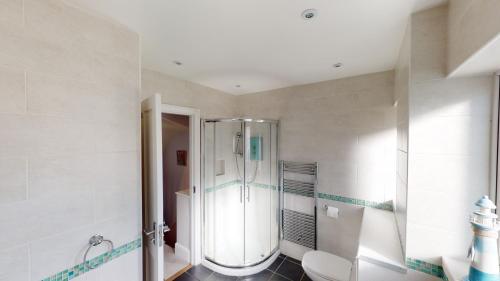 ein Badezimmer mit Dusche und Toilette in der Unterkunft Bethany Cottage in Sidmouth