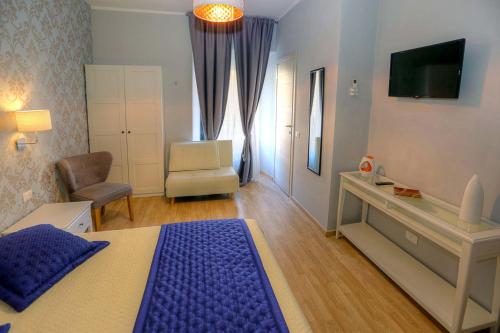 a bedroom with a bed and a chair and a television at Sweet Home Faleria in Rome