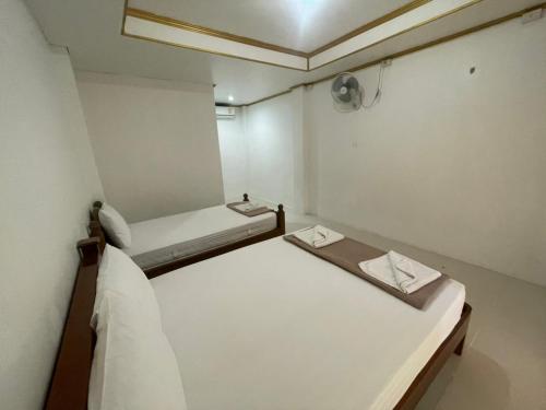 two beds in a small room with a ceiling at Pranee Bungalow in Koh Tao