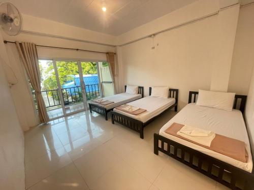 a room with two beds and a balcony at Pranee Bungalow in Koh Tao