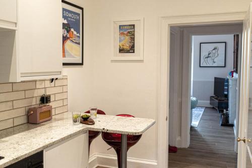 Una cocina con encimera y mesa con sillas. en 2 Claremont, en Sidmouth