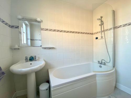 ein Badezimmer mit Waschbecken, Badewanne und Dusche in der Unterkunft Buttercup Cottage in Sidmouth