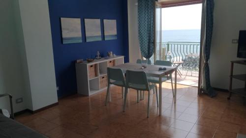 Un comedor con mesa y sillas y un balcón. en BeachFront, en Giardini Naxos