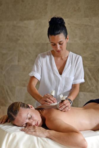 a woman cutting a mans back while laying on a bed at Casa Anamaria Hotel in Ollers