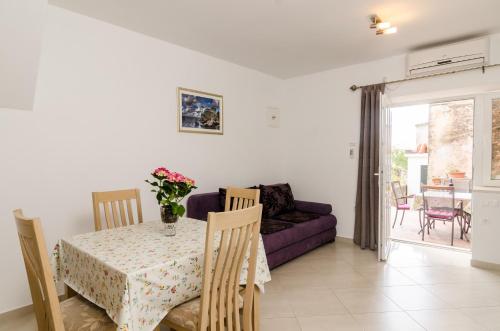 a living room with a table and a purple couch at Apartments Aurelia in Dubrovnik